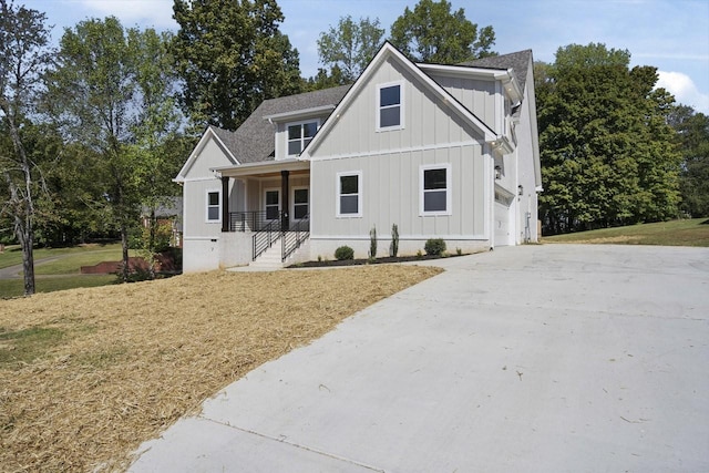 modern farmhouse style home featuring a garage, covered porch, and a front lawn