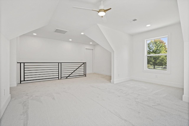 additional living space featuring ceiling fan, light colored carpet, and vaulted ceiling