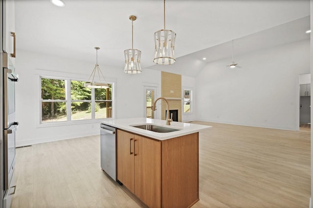 kitchen featuring pendant lighting, appliances with stainless steel finishes, a kitchen island with sink, and sink