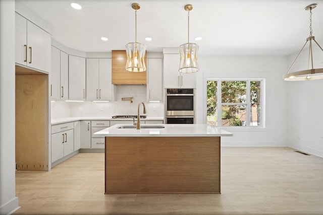 kitchen featuring white cabinetry, double oven, and sink