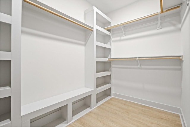 walk in closet with light hardwood / wood-style flooring