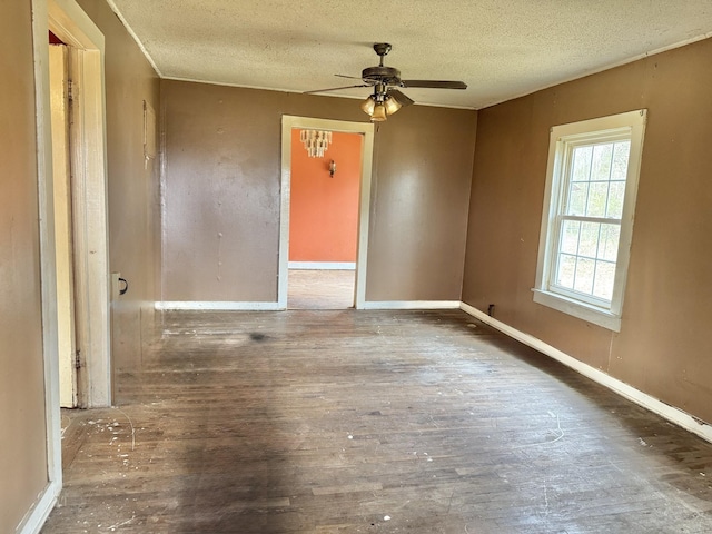 empty room with ceiling fan, dark hardwood / wood-style flooring, and a textured ceiling