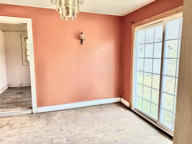 unfurnished room featuring wood-type flooring and an inviting chandelier