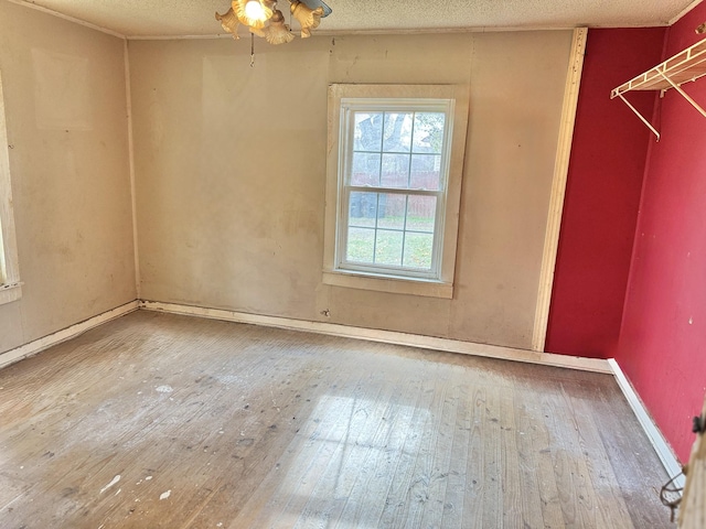 spare room featuring hardwood / wood-style floors and a textured ceiling