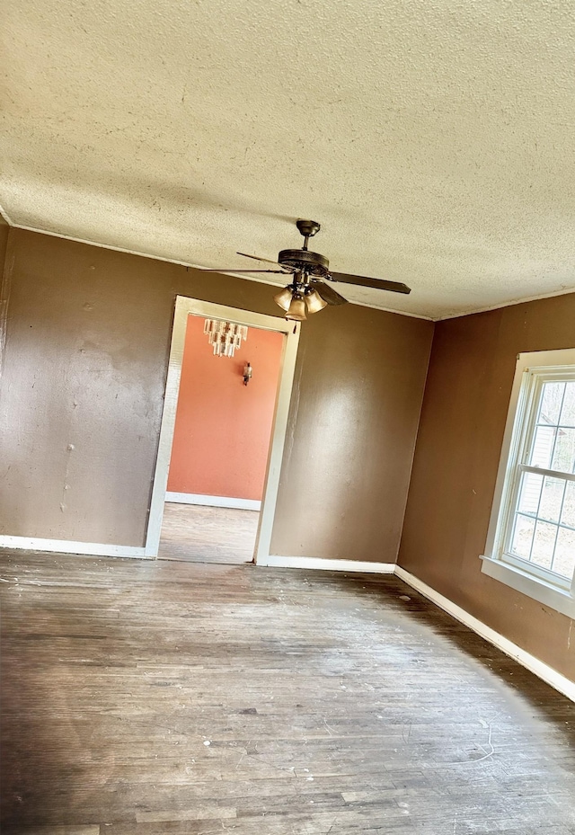 unfurnished room with ceiling fan, wood-type flooring, and a textured ceiling