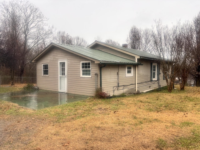 view of side of property featuring a patio area and a yard