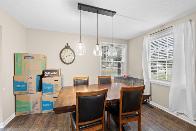 dining area featuring a textured ceiling, dark hardwood / wood-style flooring, and a healthy amount of sunlight