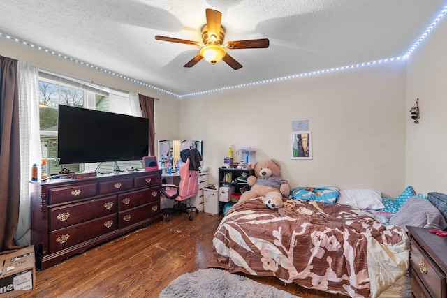 bedroom with ceiling fan, dark hardwood / wood-style floors, and a textured ceiling