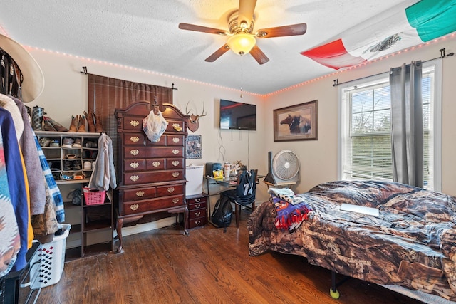 bedroom with a textured ceiling, dark hardwood / wood-style floors, and ceiling fan