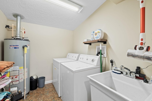 clothes washing area with a textured ceiling, separate washer and dryer, sink, and gas water heater