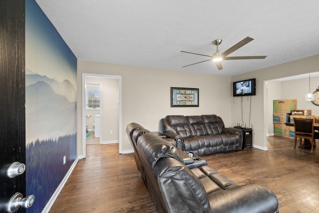 living room with dark hardwood / wood-style floors, ceiling fan, and a textured ceiling