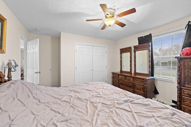 bedroom featuring ceiling fan, a closet, and a textured ceiling