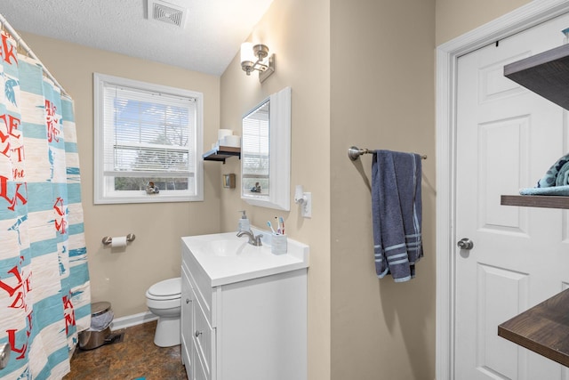 bathroom featuring a textured ceiling, vanity, and toilet