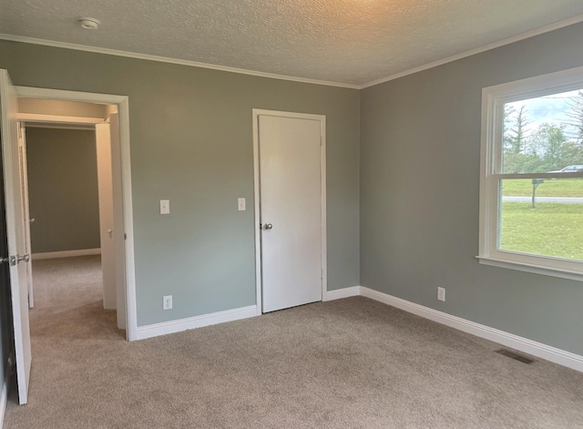 unfurnished bedroom with crown molding, light colored carpet, and a textured ceiling