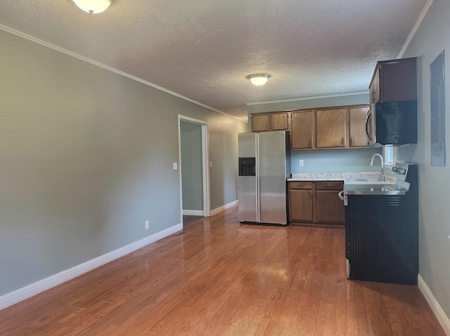 kitchen with crown molding, sink, stainless steel fridge with ice dispenser, a textured ceiling, and wood-type flooring