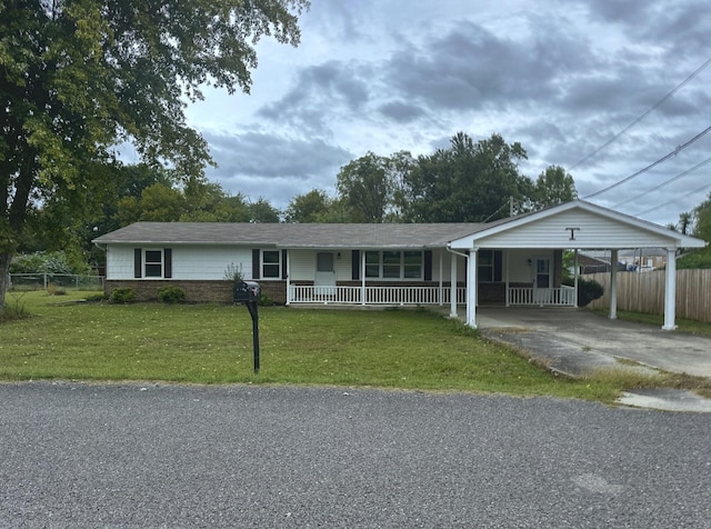 ranch-style home featuring a front yard, a carport, and covered porch