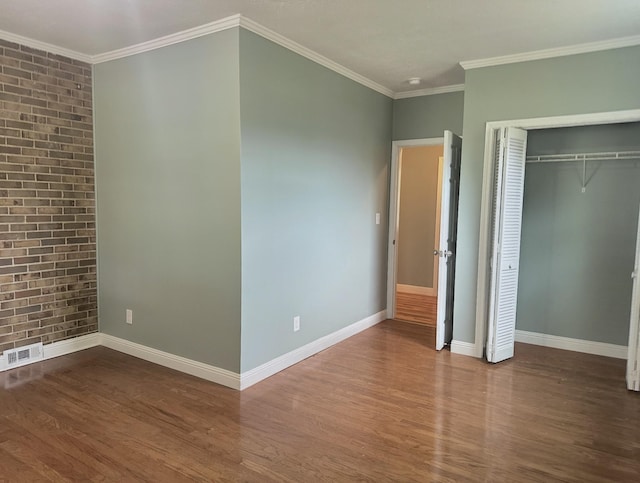 unfurnished bedroom with crown molding, dark wood-type flooring, and a closet