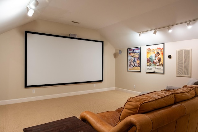 cinema room with carpet floors and vaulted ceiling