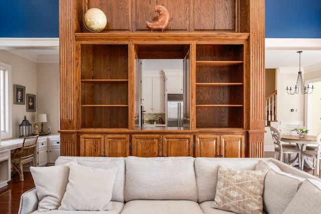 living room featuring wood-type flooring, ornamental molding, and a notable chandelier