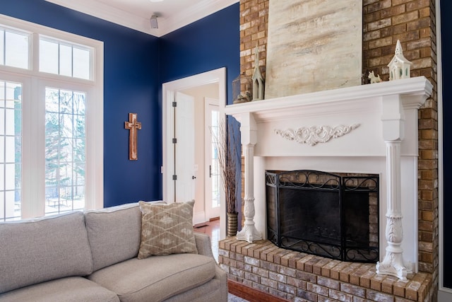 living room with a brick fireplace, crown molding, and hardwood / wood-style flooring