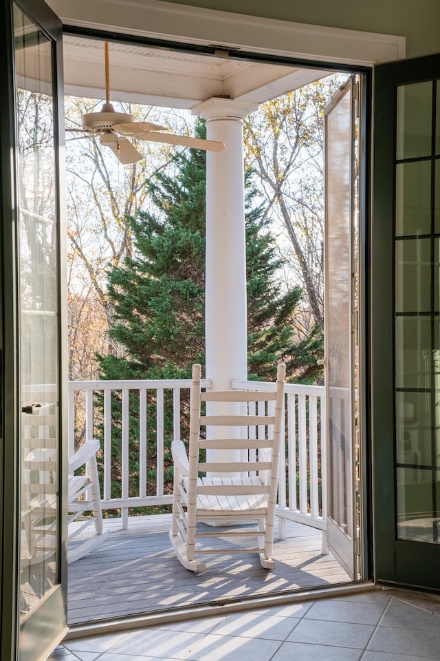 doorway with ceiling fan, light tile patterned flooring, and a wealth of natural light