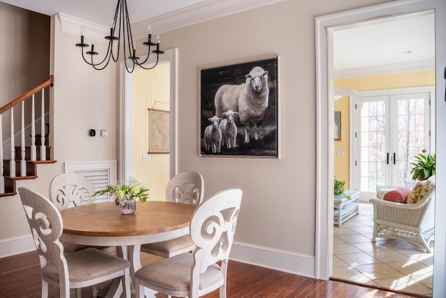 dining room with a chandelier, french doors, crown molding, and dark wood-type flooring