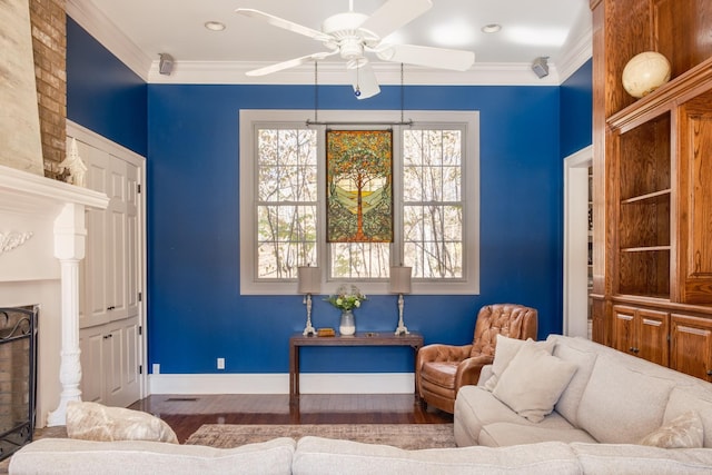 living room with hardwood / wood-style floors, a brick fireplace, ceiling fan, and crown molding