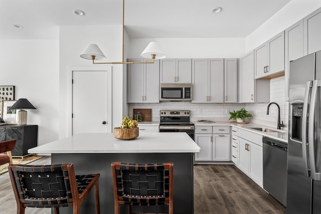 kitchen featuring sink, a center island, tasteful backsplash, dark hardwood / wood-style floors, and appliances with stainless steel finishes