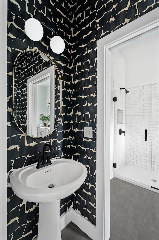 bathroom featuring tile patterned flooring and tiled shower