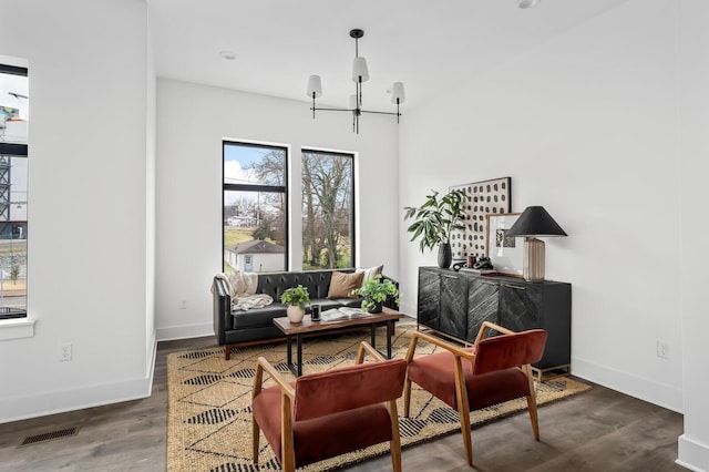 living area featuring dark hardwood / wood-style flooring and a notable chandelier