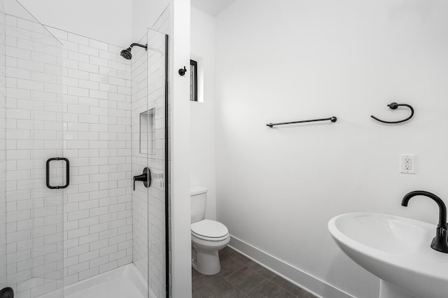 bathroom featuring tile patterned flooring, toilet, sink, and an enclosed shower