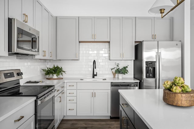 kitchen with stainless steel appliances, tasteful backsplash, dark wood-type flooring, and sink