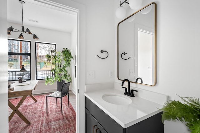 bathroom featuring hardwood / wood-style floors, vanity, and an inviting chandelier