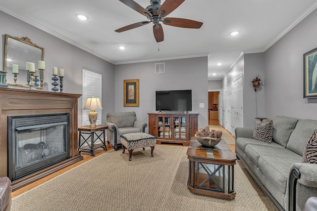 living room featuring light hardwood / wood-style floors, ceiling fan, and ornamental molding