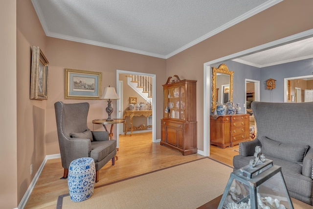 sitting room with crown molding, a textured ceiling, and light hardwood / wood-style flooring