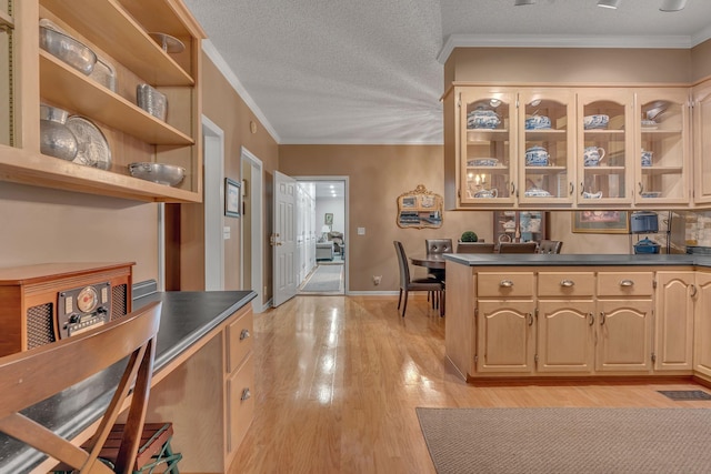 kitchen featuring light hardwood / wood-style floors, ornamental molding, a textured ceiling, and light brown cabinetry