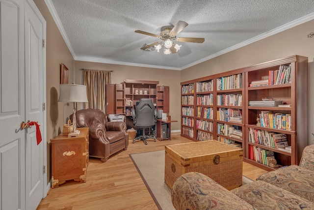 living area featuring crown molding, ceiling fan, a textured ceiling, and light wood-type flooring