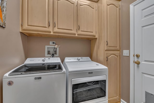 washroom featuring cabinets and separate washer and dryer