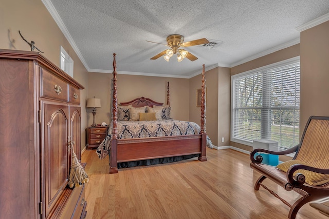 bedroom with a textured ceiling, light hardwood / wood-style flooring, ceiling fan, and ornamental molding