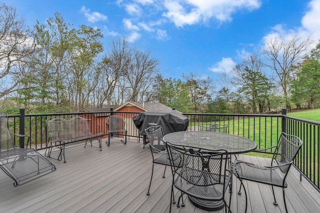 wooden deck featuring area for grilling and a lawn