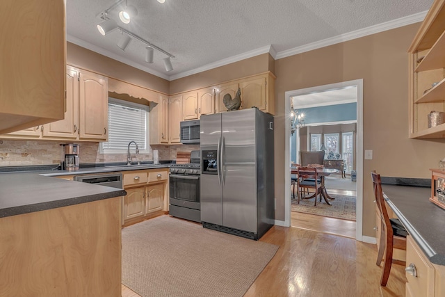 kitchen with light hardwood / wood-style floors, sink, a textured ceiling, and appliances with stainless steel finishes