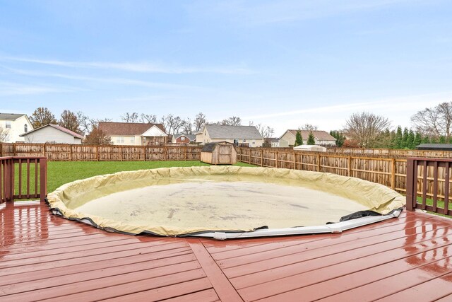 deck with a storage shed and a yard