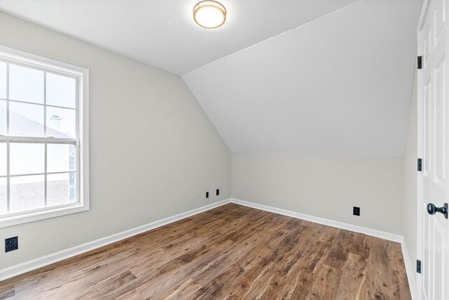 bonus room featuring plenty of natural light, lofted ceiling, and hardwood / wood-style flooring