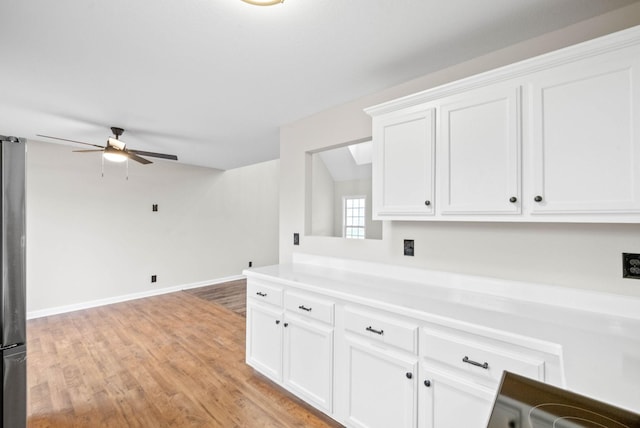 interior space with ceiling fan, white cabinetry, and light hardwood / wood-style flooring