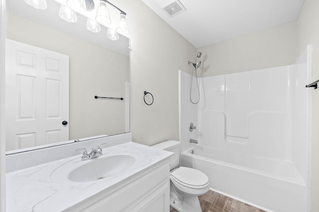 full bathroom with hardwood / wood-style floors, vanity, toilet, and shower / washtub combination