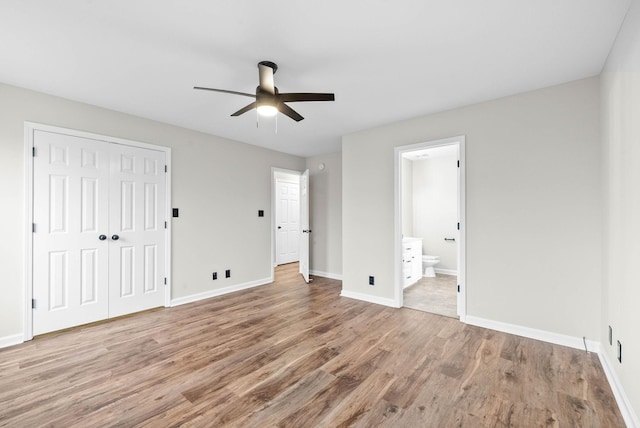 unfurnished bedroom with hardwood / wood-style floors, ceiling fan, connected bathroom, and a closet