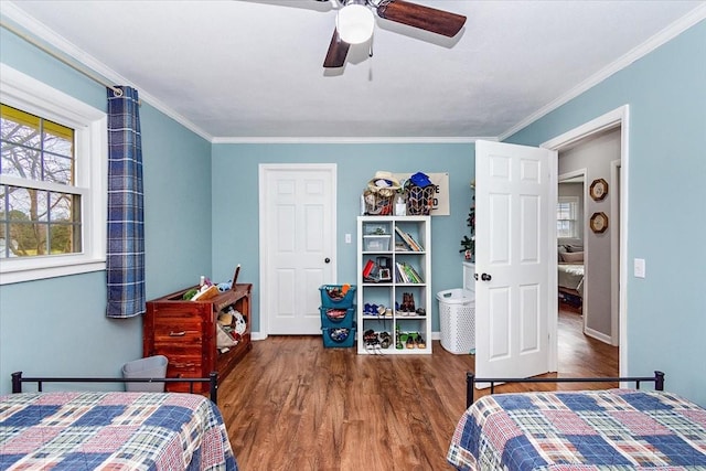 bedroom with ceiling fan, crown molding, and dark wood-type flooring