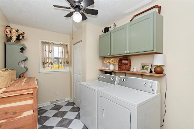 laundry room with washing machine and clothes dryer, ceiling fan, cabinets, and a textured ceiling