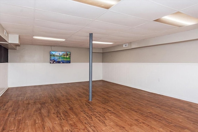 basement with dark hardwood / wood-style floors and a drop ceiling