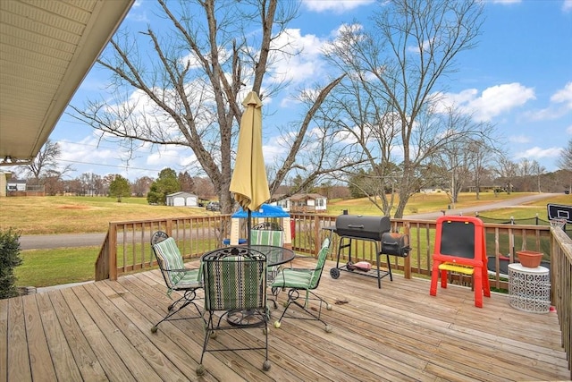 wooden terrace with area for grilling and a lawn